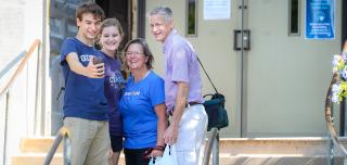 Parents and students take a selfie together in front of St. John's